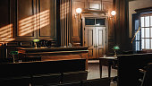 istock Empty American Style Courtroom. Supreme Court of Law and Justice Trial Stand. Courthouse Before Civil Case Hearing Starts. Grand Wooden Interior with Judge's Bench, Defendant's and Plaintiff's Tables. 1346156607