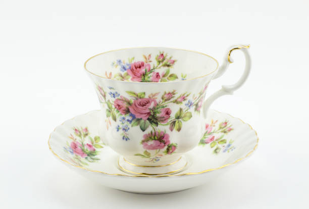Empty antique cup and saucer with rose decoration isolated on white - English tea stock photo