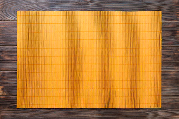 sfondo alimentare asiatico vuoto. tappeto giallo bamboo su sfondo in legno vista superiore con copia spazio piatto laici - tovaglietta foto e immagini stock