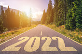 istock Empty asphalt road and New year 2022 concept. Driving on an empty road in the mountains to upcoming 2022. Concept for success and passing time. 1295078108