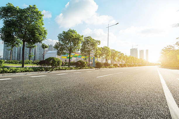 empty asphalt road in modern city at sunrise stock photo