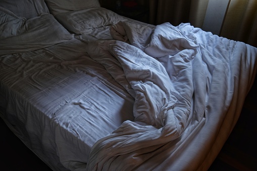 empty-bed-and-unmade-at-the-first-light-of-dawn-picture-id1007422926