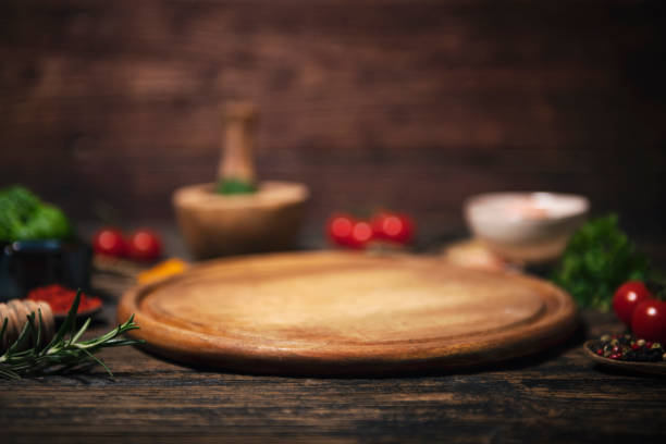 Empty board for pizza on wooden desk stock photo