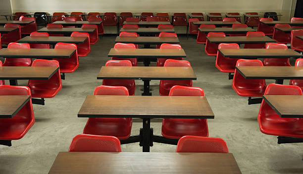 Empty classroom fill with red lecture seats stock photo