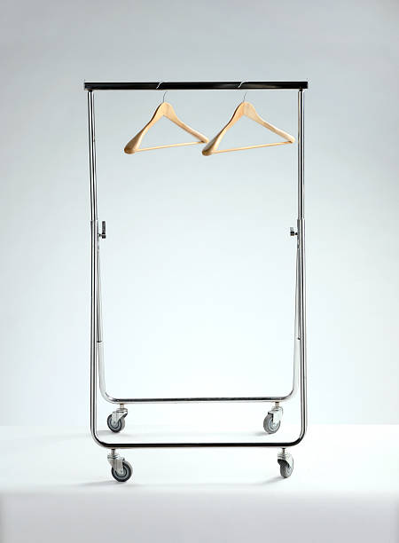 empty clothes rack, economic depression empty chrome clothes rack with two empty hangers on white background clothes rack stock pictures, royalty-free photos & images