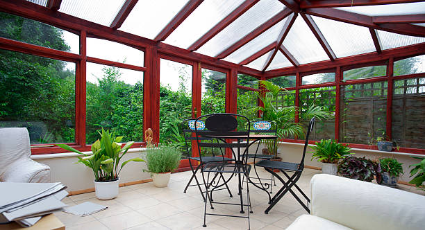 A empty conservatory with plans conservatory tables chairs plants room in house next to garden greenhouse table stock pictures, royalty-free photos & images
