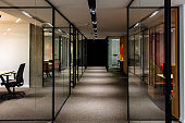 istock Empty corridor in modern office building at night 1313115403