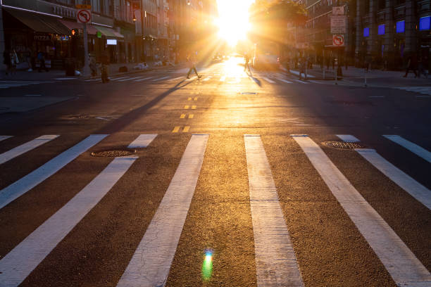 Empty crosswalk with no people on 14th Street in New York City with sunlight shining in the background stock photo