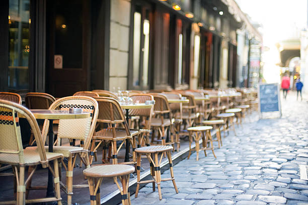 Empty dining tables and chairs in Paris alley way stock photo