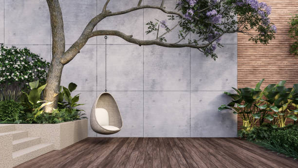 Empty exterior concrete wall with wicker swing hang on the tree 3d render stock photo