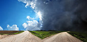 istock Empty forked road over conceptual dramatic sky 1368663179