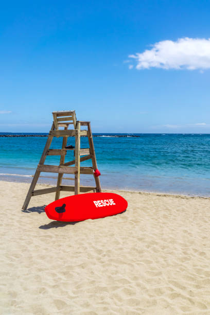 Empty Lifeguard Chair and Rescue Surf Board stock photo