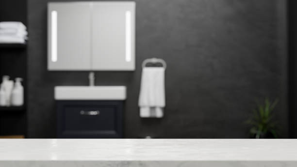 Empty marble tabletop for montage over blurred modern dark bathroom stock photo
