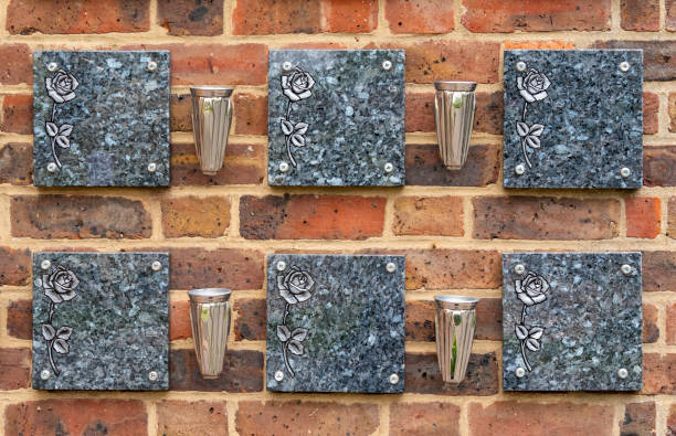 Empty memorial plaques on a wall at a crematorium Two rows of blank marble memorial plaques on a brick wall at a crematorium, separated by empty vases. crematorium stock pictures, royalty-free photos & images