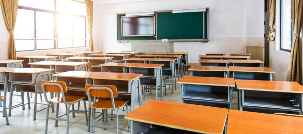 Empty modern classroom with chairs, desks and chalkboard stock photo
