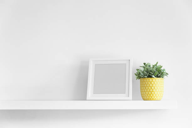 Empty picture frame on a floating shelf stock photo