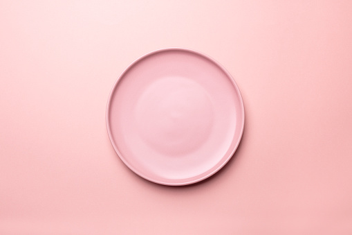 Empty pink plates on pink  background with clipping Path. Top view.