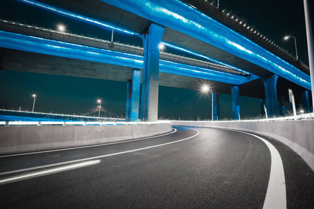 Empty road floor with city viaduct bridge of neon lights night stock photo