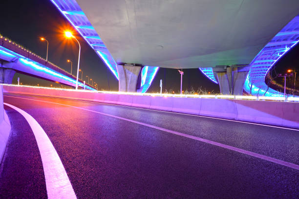 Empty road floor with city viaduct bridge of neon lights night stock photo