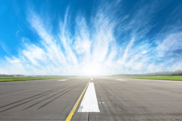 Empty runway strip with markings with beautiful clouds on the horizon. Empty runway strip with markings with beautiful clouds on the horizon airport runway stock pictures, royalty-free photos & images