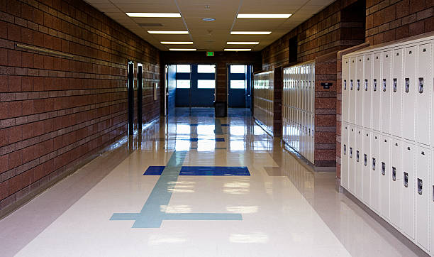 Empty School Hallway An empty school hallway lined with lockers. corridor stock pictures, royalty-free photos & images