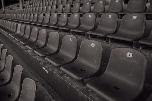 empty seats in a sports stadium, no fans, no people, black and white photo