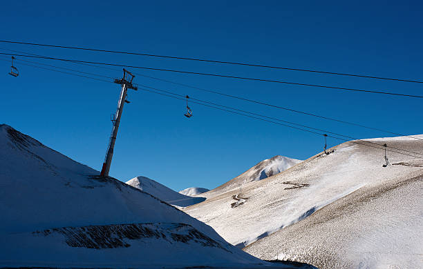 Empty ski lifts over snowy mountain top Empty ski lifts over snowy mountain top t bar ski lift stock pictures, royalty-free photos & images