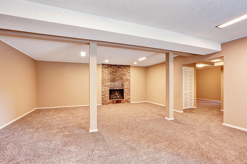 Empty Spacious Room With Brick Fireplace And Carpet Floor