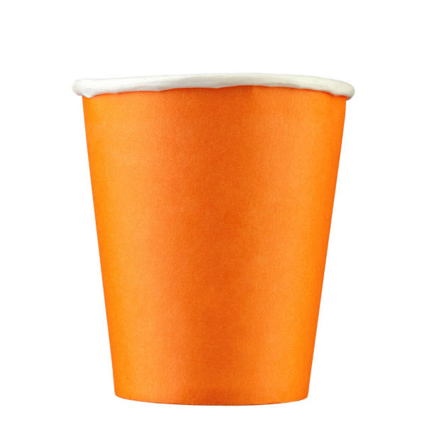 Empty takeaway coffee paper cup in orange color isolated on white background. This photo is suitable for use as a mockup to put your logo or design on it. stock photo