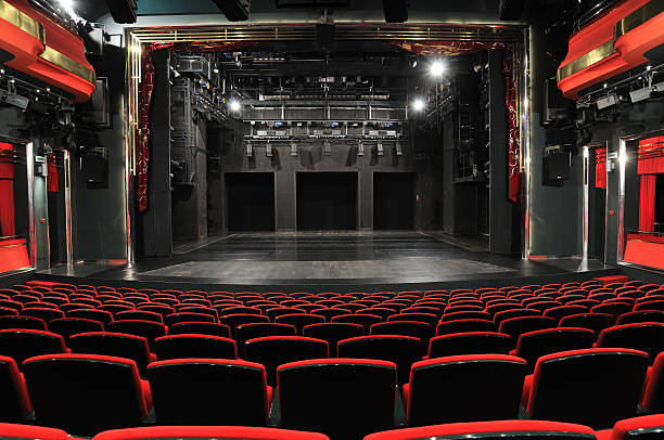 Empty theater from the view of the back row Empty theater with red seats and black stage. theatrical performance stock pictures, royalty-free photos & images