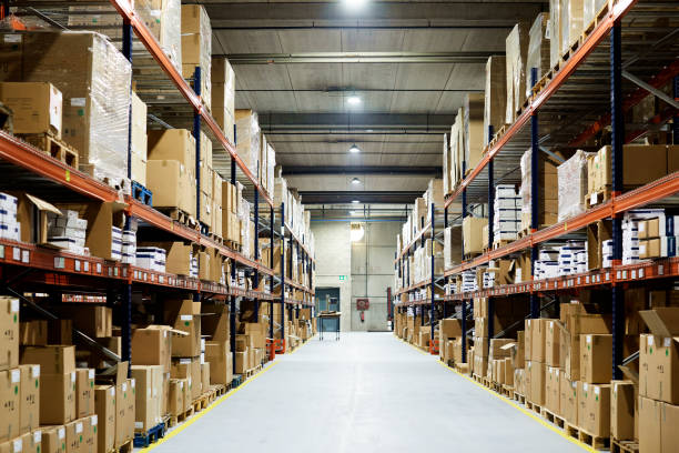 Empty warehouse, view down the asile with shelves and boxes. Empty warehouse. storage space stock pictures, royalty-free photos & images