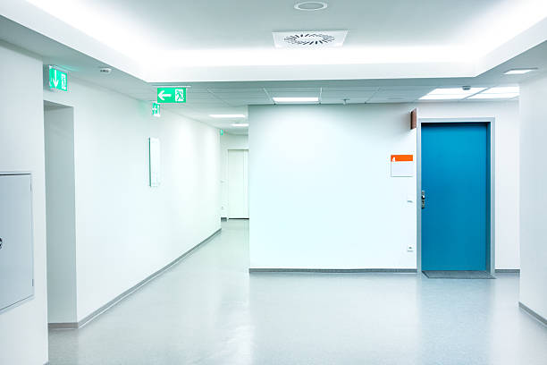 Empty white Hospital corridor with a blue door Hospital corridor entrance sign stock pictures, royalty-free photos & images