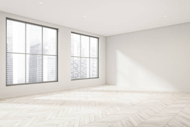 Empty white room with light wood floor and windows. Corner view. stock photo