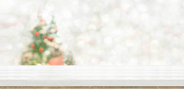 пустой белый деревянный столешница с абстрактным теплым декором гостиной с рождественской елкой строки света размытия фон со снегом, праз� - christmas table стоковые фото и изображения