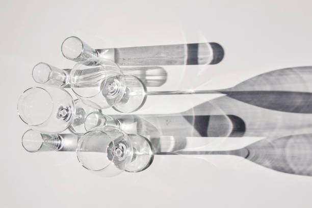 Empty wine glasses and glasses. Abstract shadows, sunlight, white background. stock photo