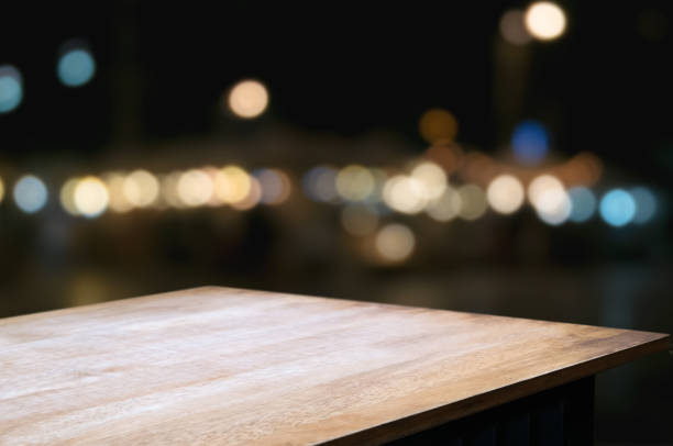 empty wood table in front of blurred montage night market bokeh background empty wood table in front of blurred montage night market bokeh background point of view stock pictures, royalty-free photos & images