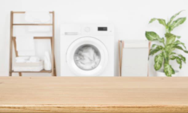 Empty wooden board over blurred laundry room washing machine background Empty wooden board over blurred laundry room washing machine background art and craft product stock pictures, royalty-free photos & images