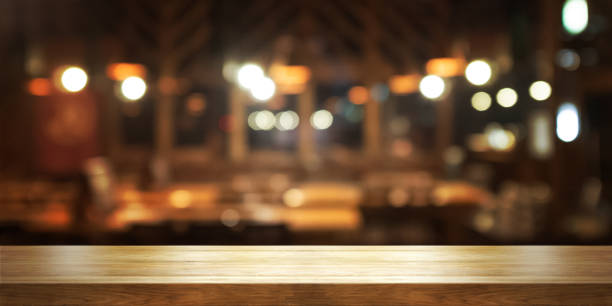 dessus de table en bois vide avec le café de flou ou le fond intérieur de restaurant, - bar photos et images de collection