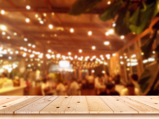 Empty wooden table top with blur coffee shop or restaurant interior background stock photo
