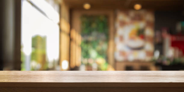 Empty wooden table top with blur coffee shop or restaurant interior background, Panoramic banner. Empty wooden table top with blur coffee shop or restaurant interior background, Panoramic banner. Abstract background can be used product display. diminishing perspective stock pictures, royalty-free photos & images