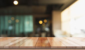 istock Empty wooden table top with lights bokeh on blur restaurant background 1337869850