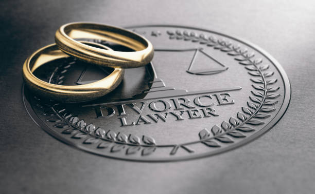 Ending a Marriage, Divorce Lawyer Concept 3D illustration of two used golden rings over a divorce lawyer sign unbossed on a black paper. images of divorce stock pictures, royalty-free photos & images