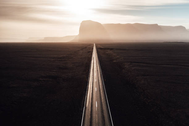 Endless straight road into the sun on Iceland stock photo