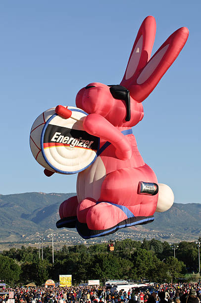 Energizer Bunny Hot Air Balloon Rising Over Crowd at Sunrise stock photo