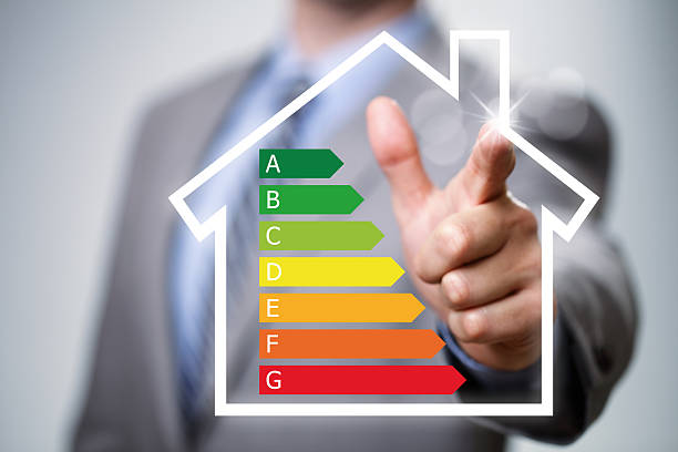 Energy efficiency in the home Businessman pointing to energy efficiency rating chart and house icon concept for performance, efficiency and environmental conservation energy efficient stock pictures, royalty-free photos & images