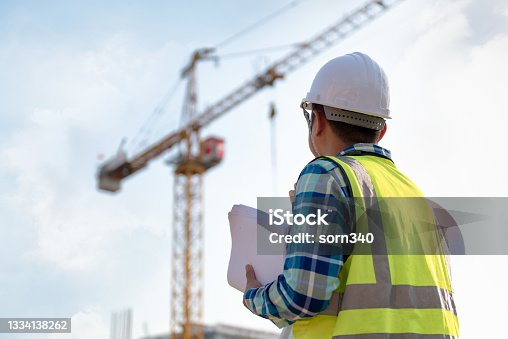 istock Engineering Consulting people on construction site holding blueprint in his hand and control workflow of the new building. 1334138262