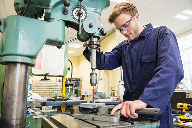 Engineering student using large drill stock photo