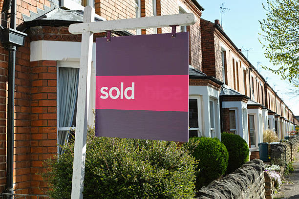 English suburban house with 'sold' sign. stock photo