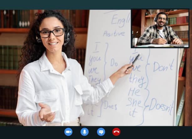 English teacher explaining lesson to indian man, talking to camera Online Tutoring. Portrait Of Woman In Glasses And Headset Having Video Conference, Teaching Foreign Languages, Talking To Camera During Web Call, Indian Student Sitting At Desk At Home And Writing english language stock pictures, royalty-free photos & images