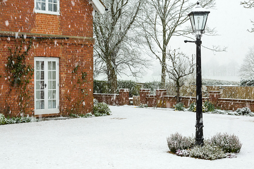 English garden of a country house in winter snow, UK